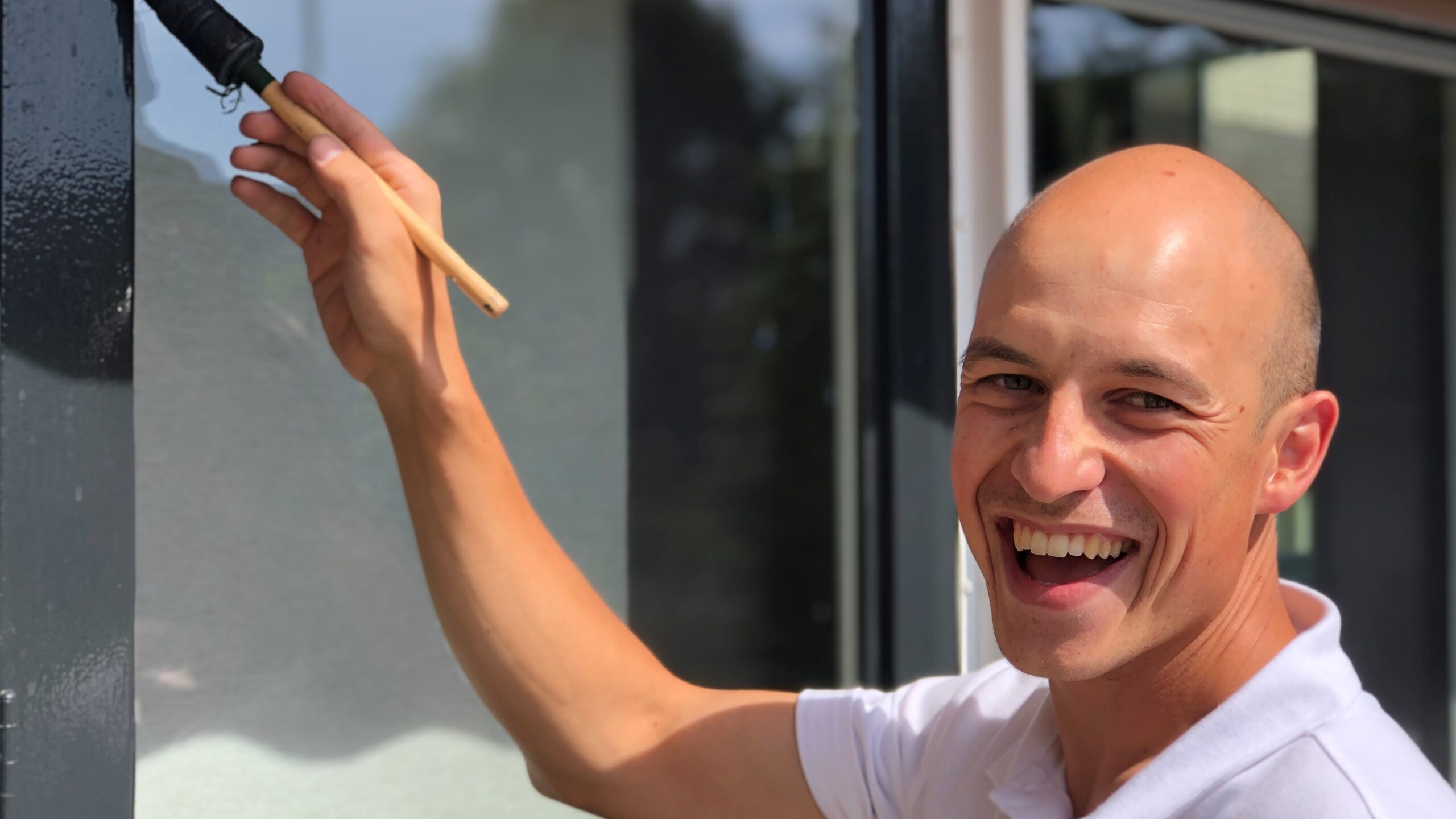 Jayjay de Loos aan het schilderen van een kozijn